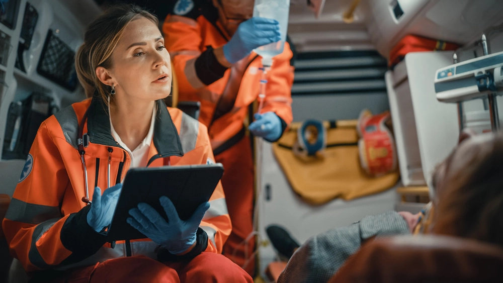 Stock image of a Wireless Networks Emergency Services worker on an ipad in an ambulance