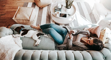 young woman using her cellphone while relaxing at home  
