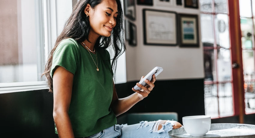Young woman using smartphone in coffeeshop 