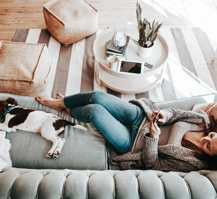 young woman using her cellphone while relaxing at home  