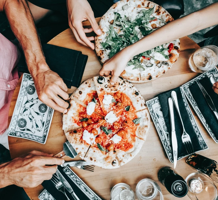 Family sharing pizza at a casual dining table. 