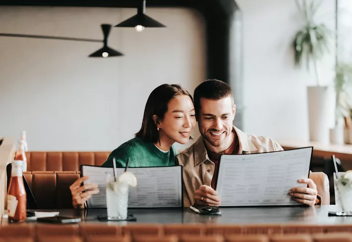 A smiling, young couple enjoys a cozy dining moment in a modern restaurant.  