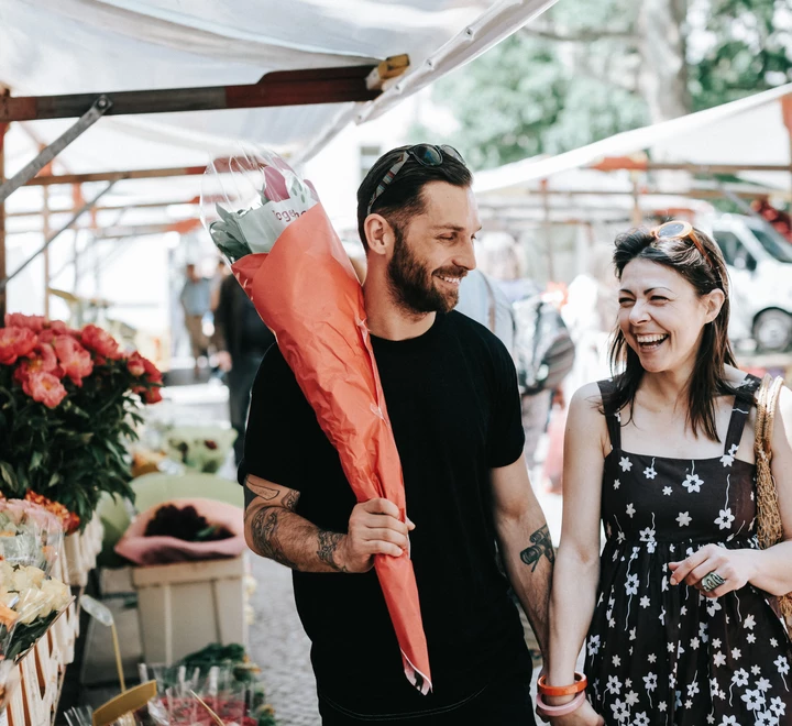 Happy couple walking through Farmer's Market. 