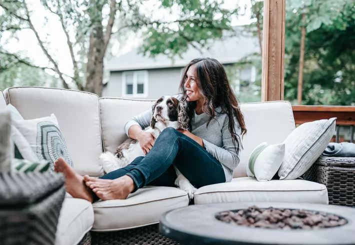Woman relaxing on sofa with dog 