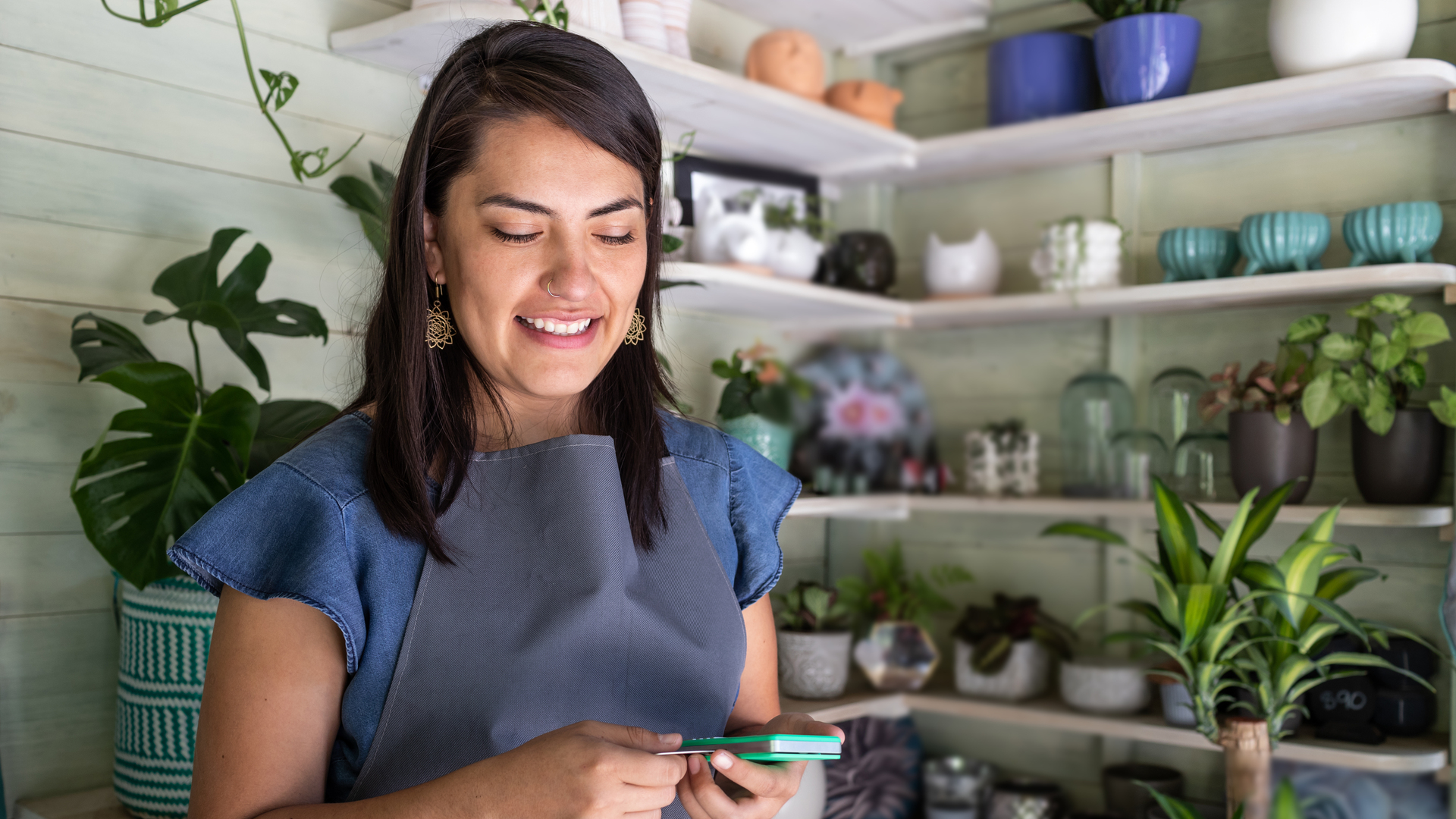 Young woman smiling receiving payment on mobile credit card reader