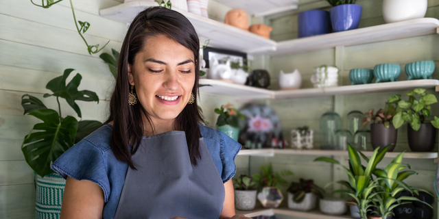 Young woman smiling receiving payment on mobile credit card reader