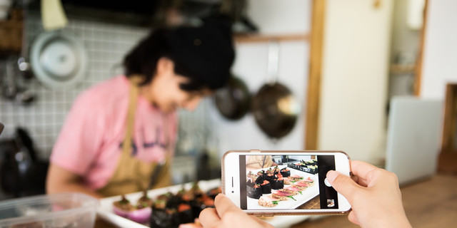 Customer shooting sushi made with vegan ingredients with smartphone