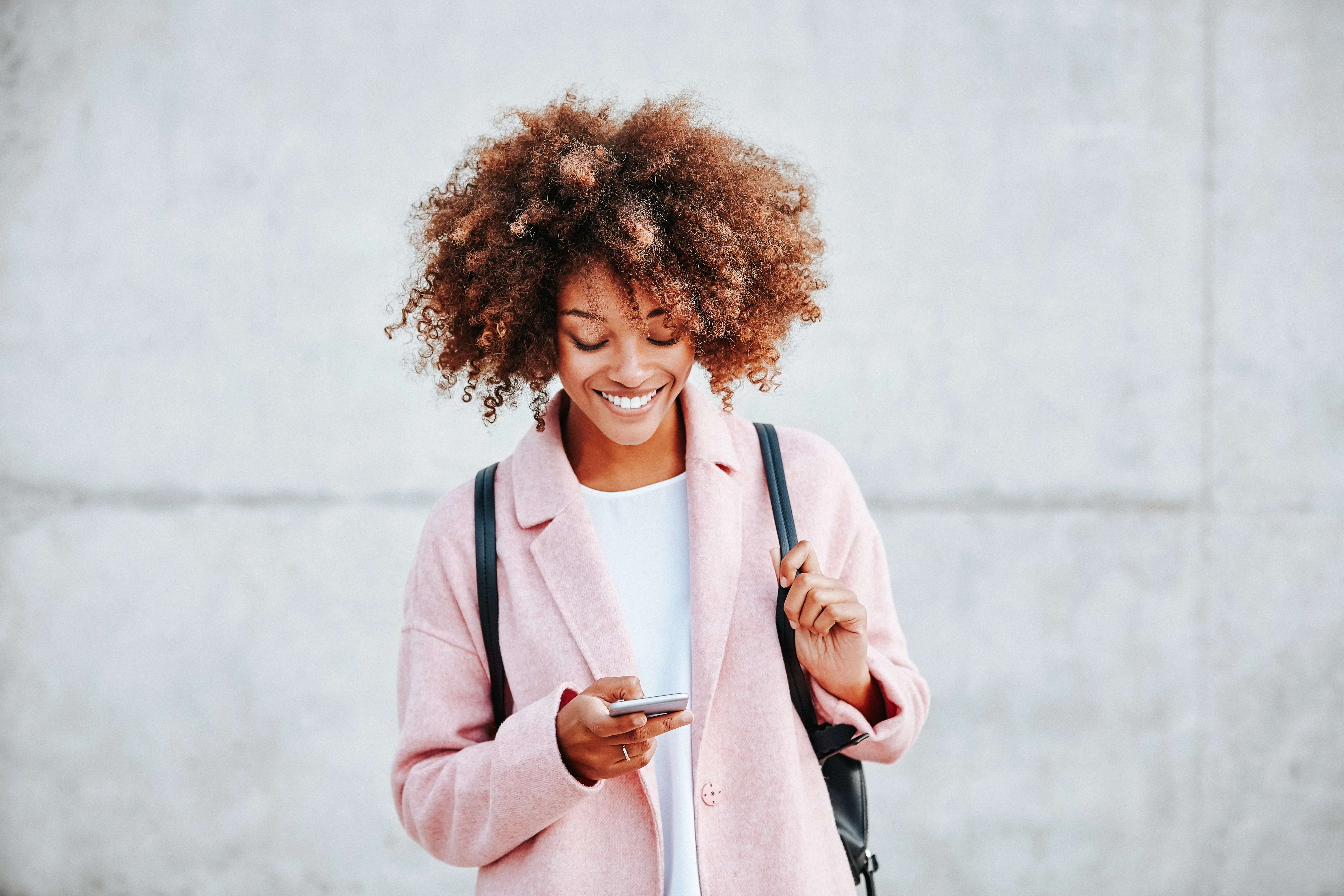 Happy young woman text messaging through smart phone. 