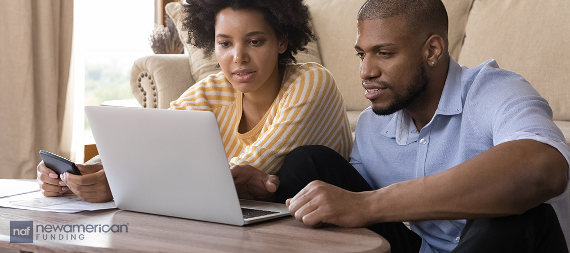 couple looking a laptop on the floor in the living room