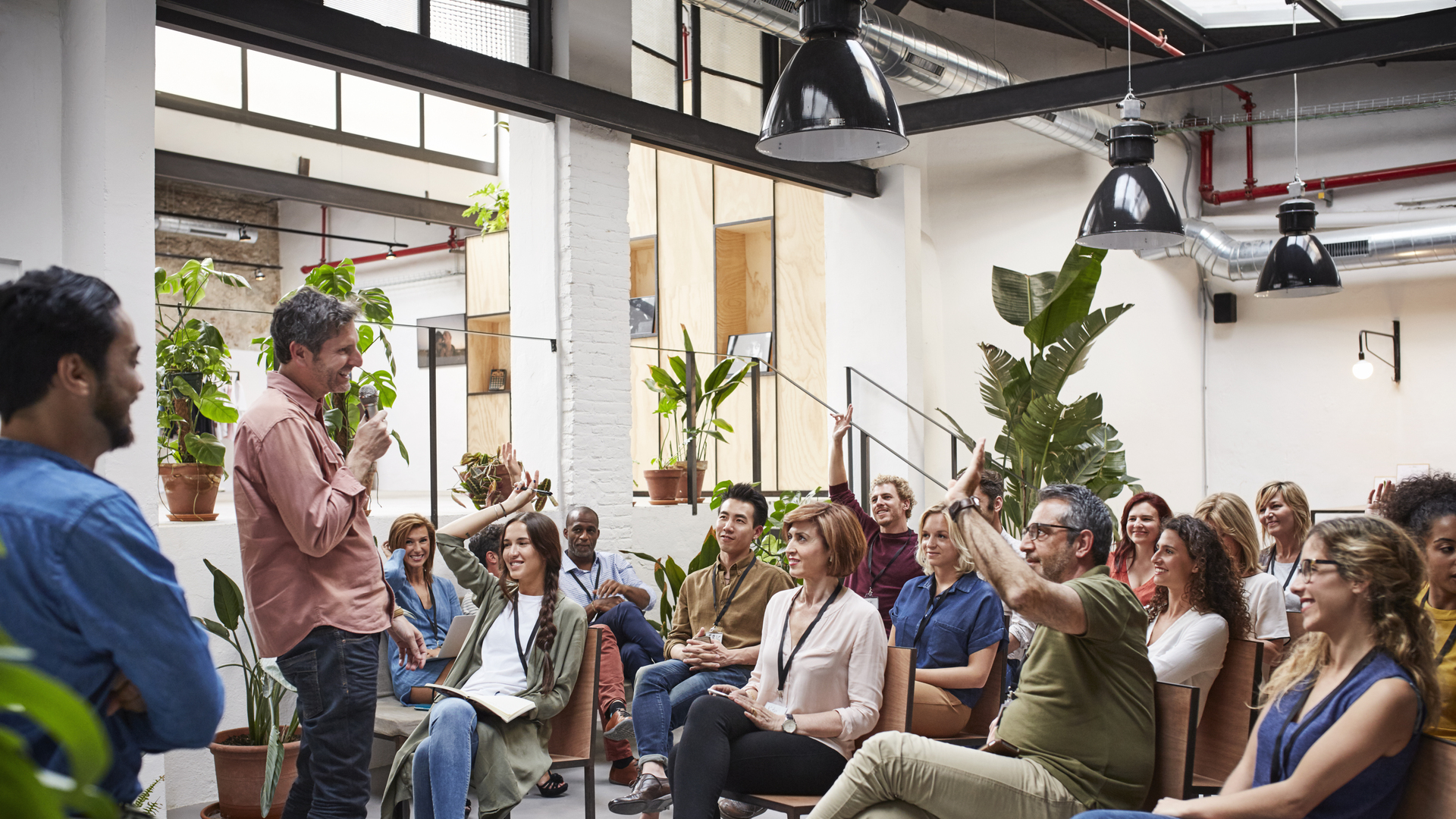 Business people with raised arms during seminar