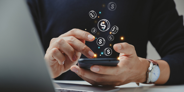 Hand of businessman using smart phone with coin icon.