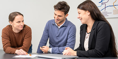 Three co-workers discussing business conduct