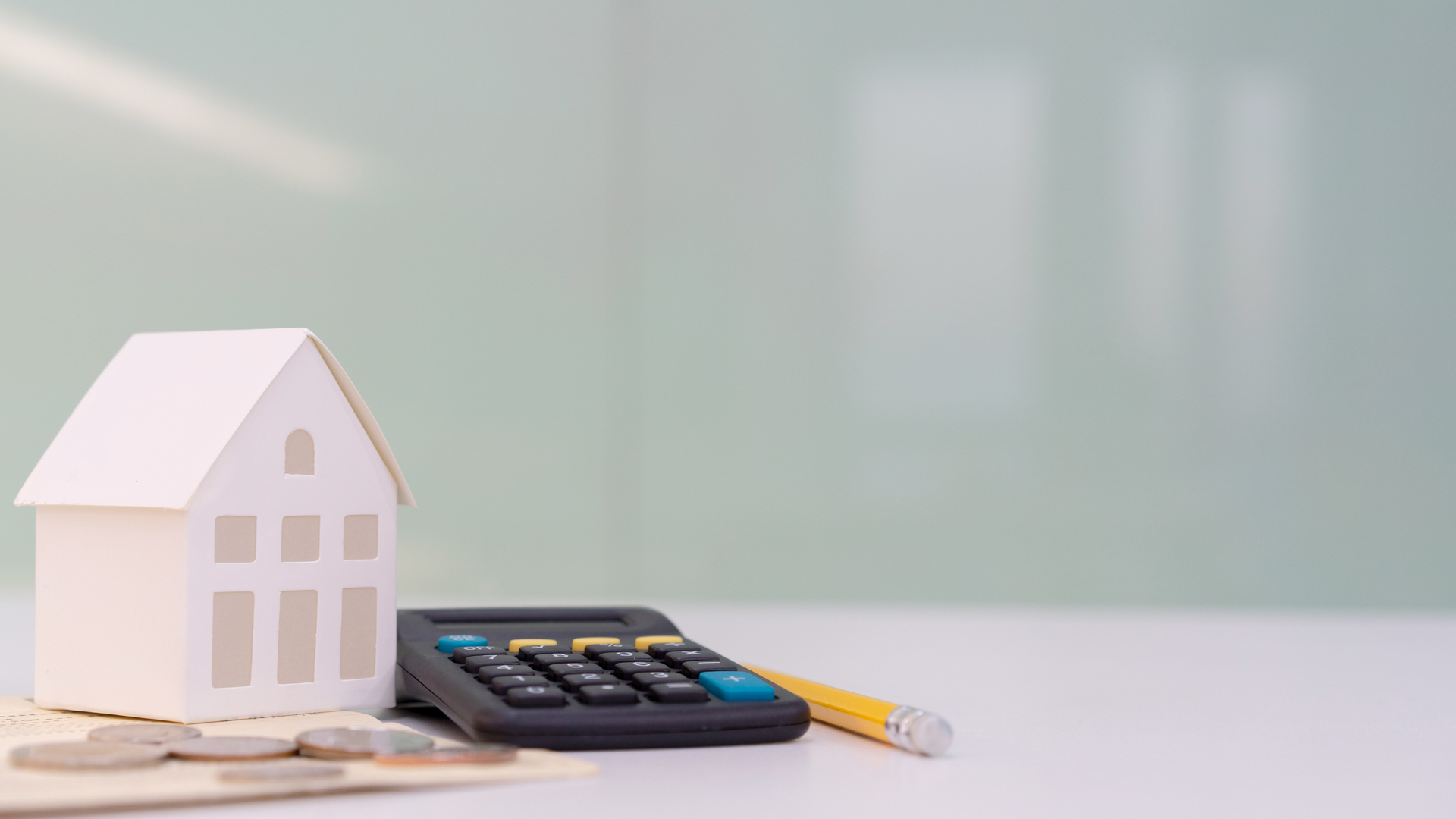 close up house's model on banking account book with calculator, coin and pencil on table for planning of home loan mortgage refinance or retention interest rates , business and financial concept