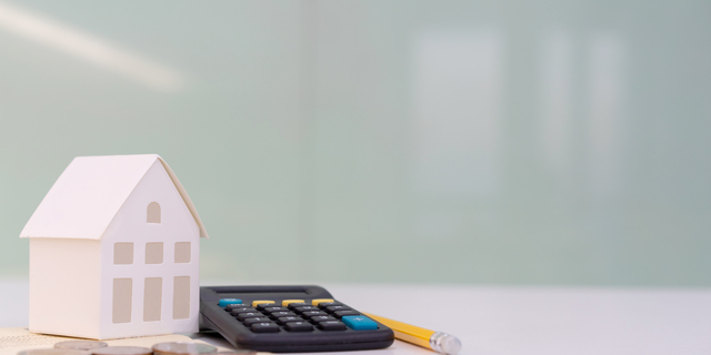 close up house's model on banking account book with calculator, coin and pencil on table for planning of home loan mortgage refinance or retention interest rates , business and financial concept