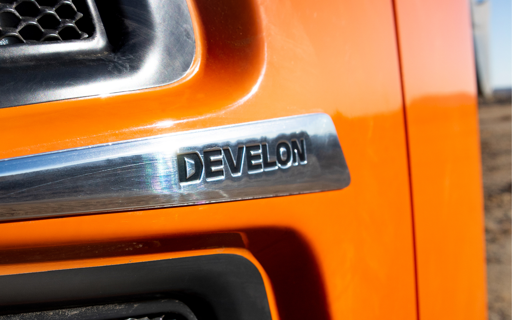 Close-up of the DEVELON logo on the back of a DEVELON mini excavator