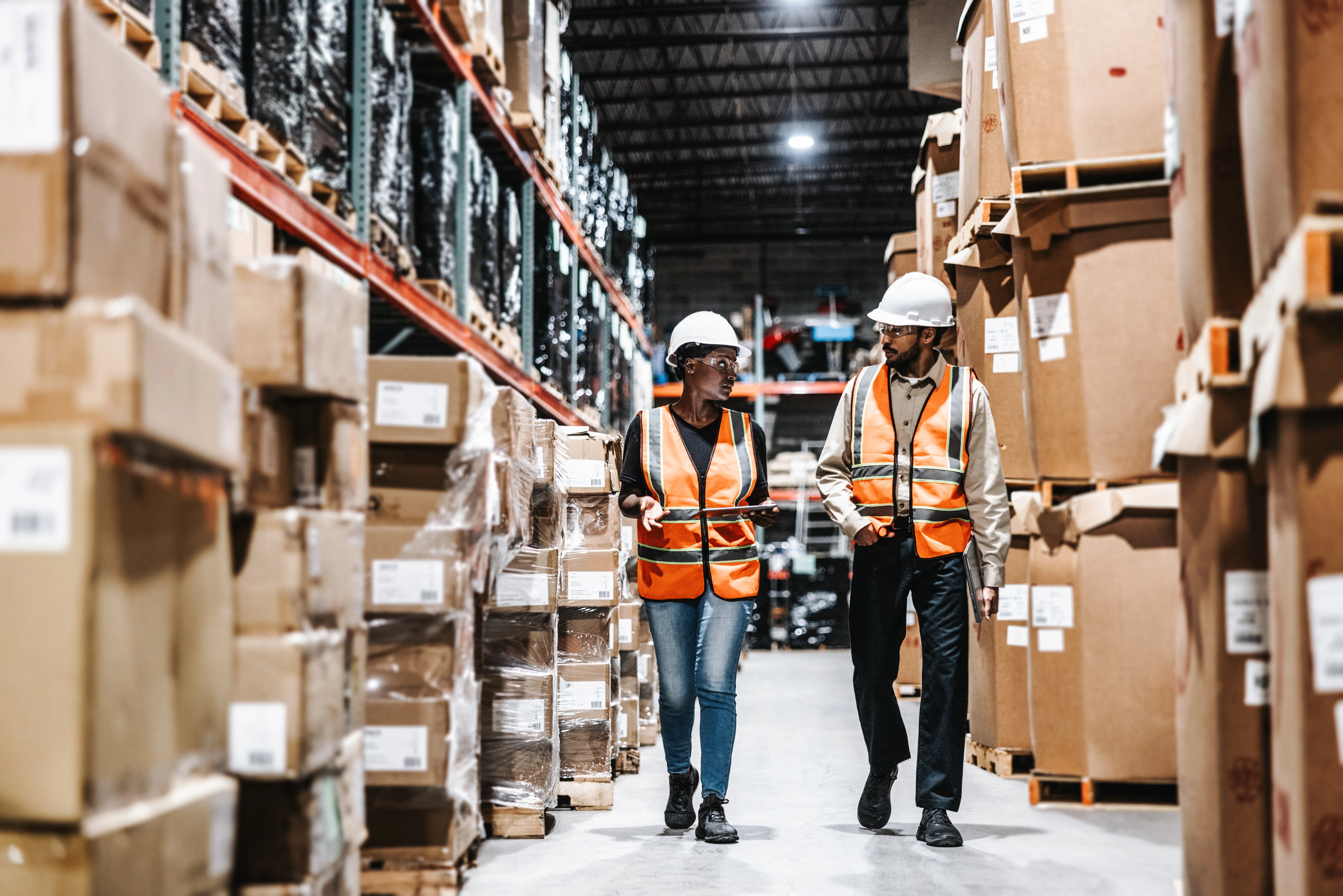 Warehouse employees walking in aisle of warehouse 