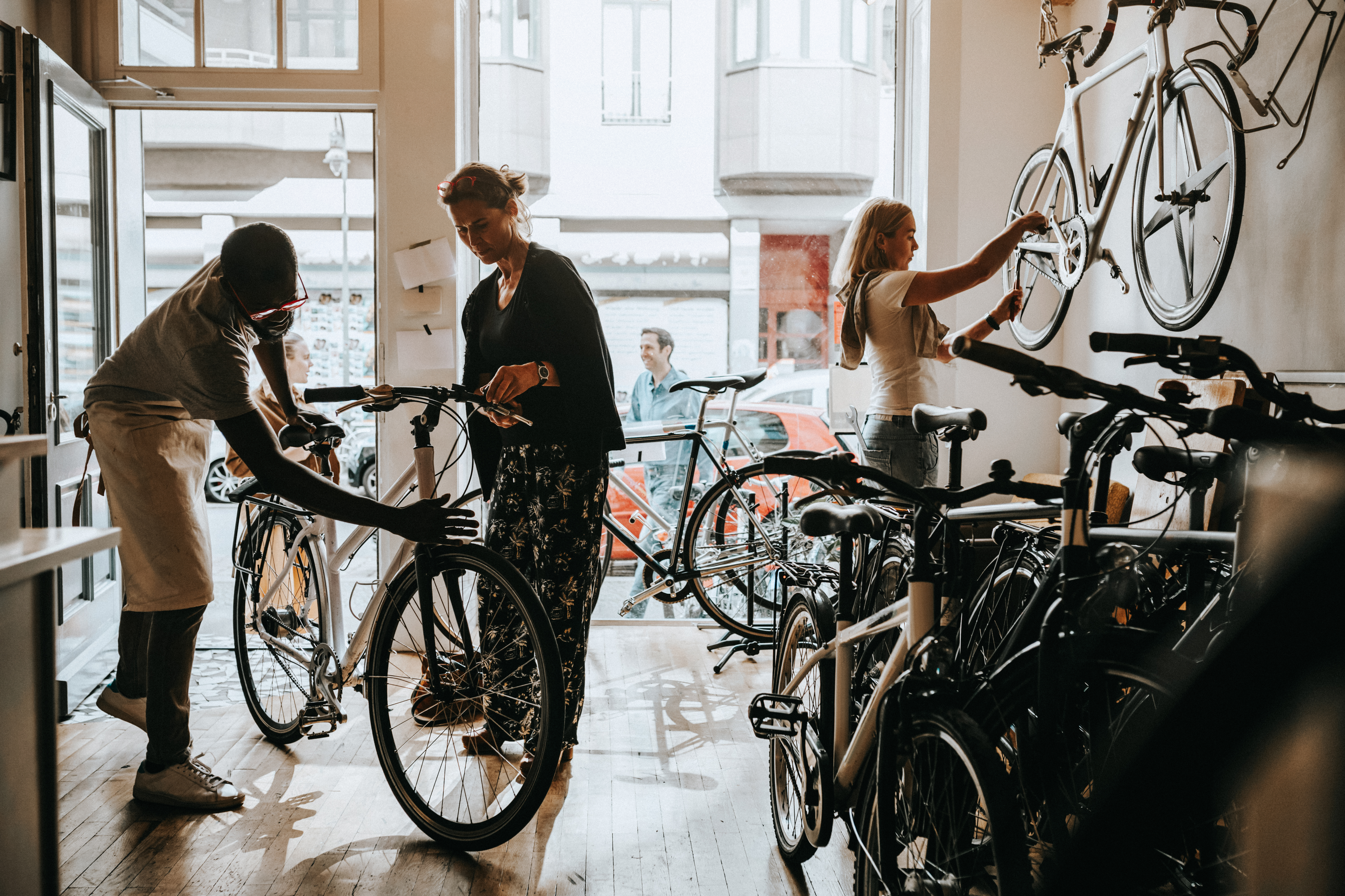 African American business owner in bicycle shop helping customer with bike 
