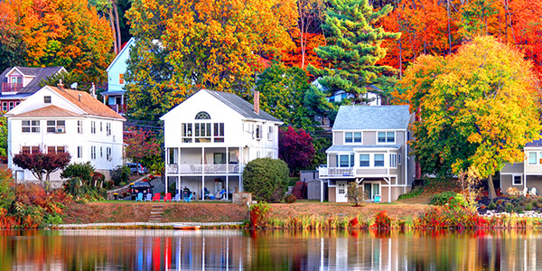 houses on a lakeside surrounded by vibrant-colored trees