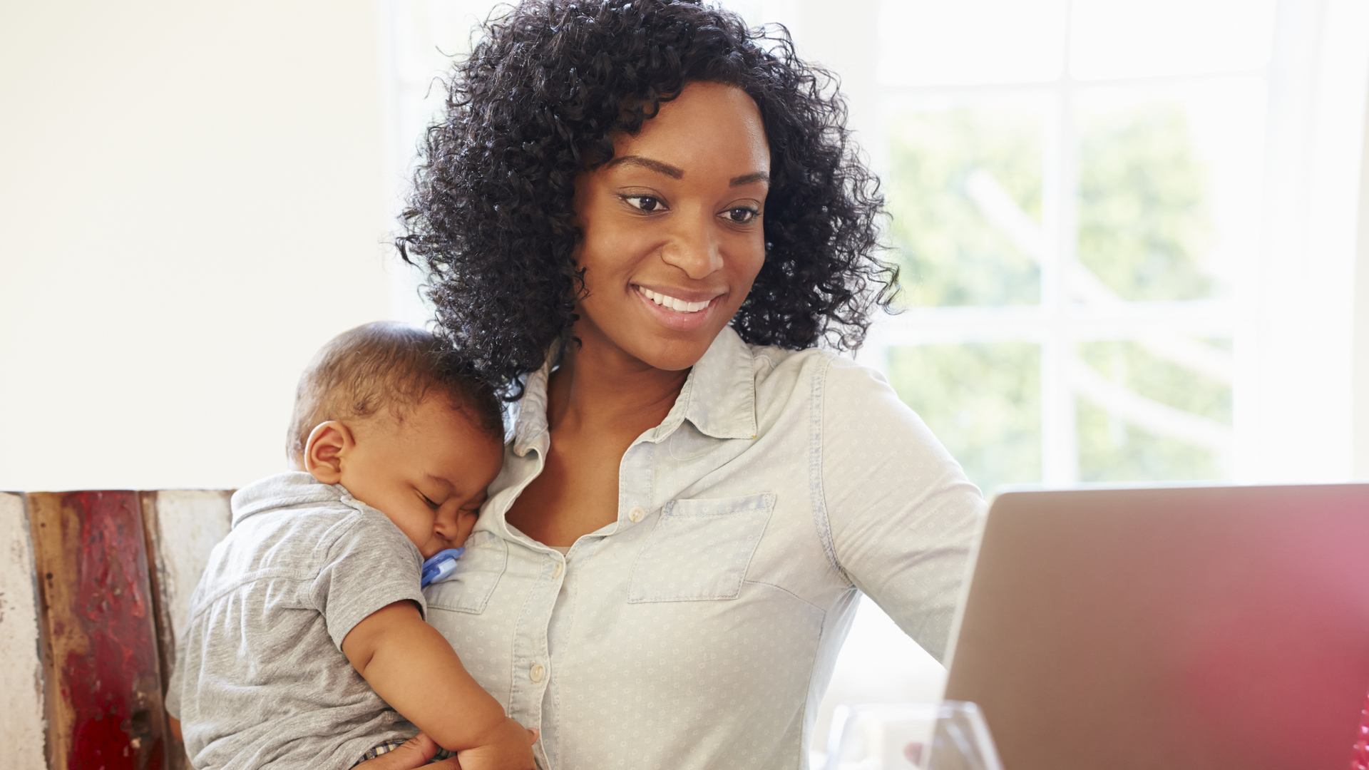 Mother With Baby Working In Office At Home