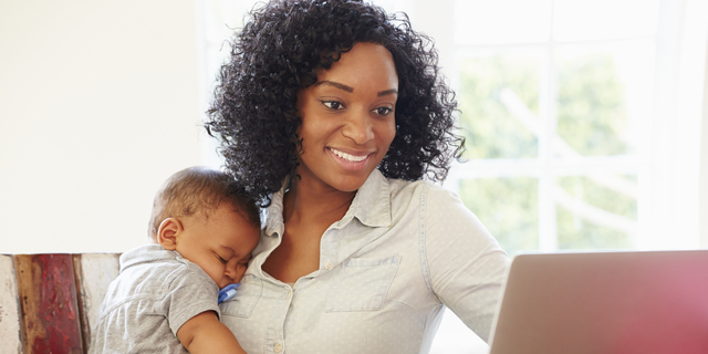 Mother With Baby Working In Office At Home