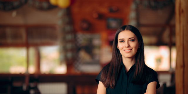 Manager Standing in a Restaurant Welcoming Customers