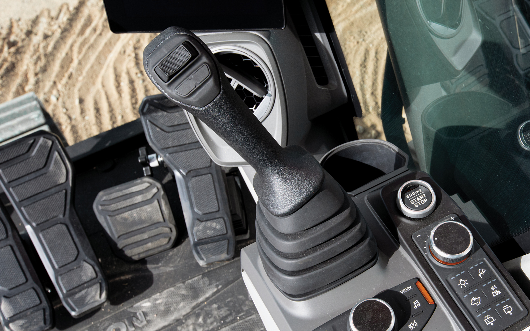 A joystick in a DEVELON heavy equipment cab.