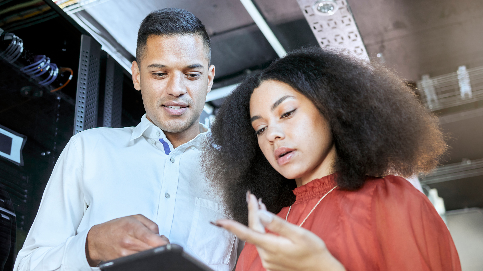 Tablet, woman and man check cyber security, connect server internet or coding information. IT specialist, female programmer and male coder talk with digital device for system admin or cloud computing