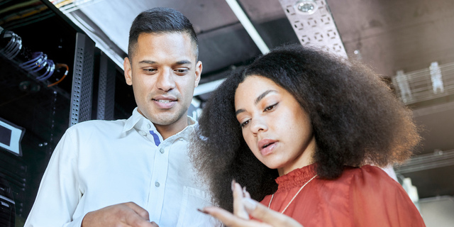 Tablet, woman and man check cyber security, connect server internet or coding information. IT specialist, female programmer and male coder talk with digital device for system admin or cloud computing