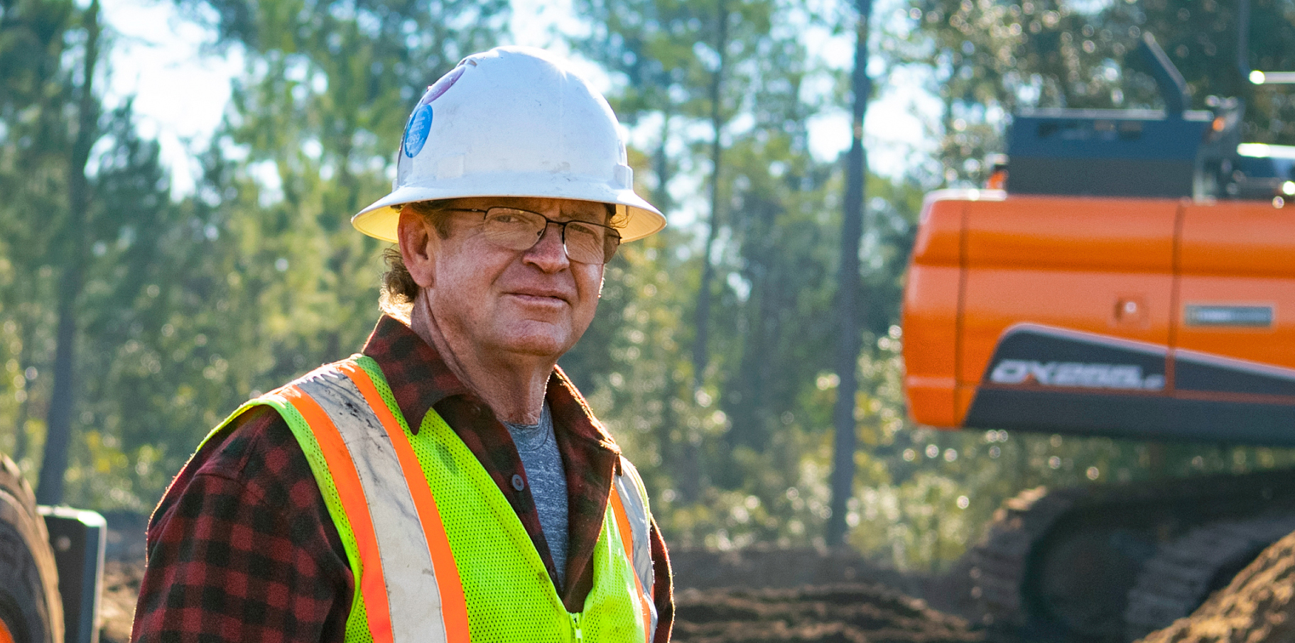 Wendell O’steen of Atlantic Contracting standing in front of a DEVELON machine.