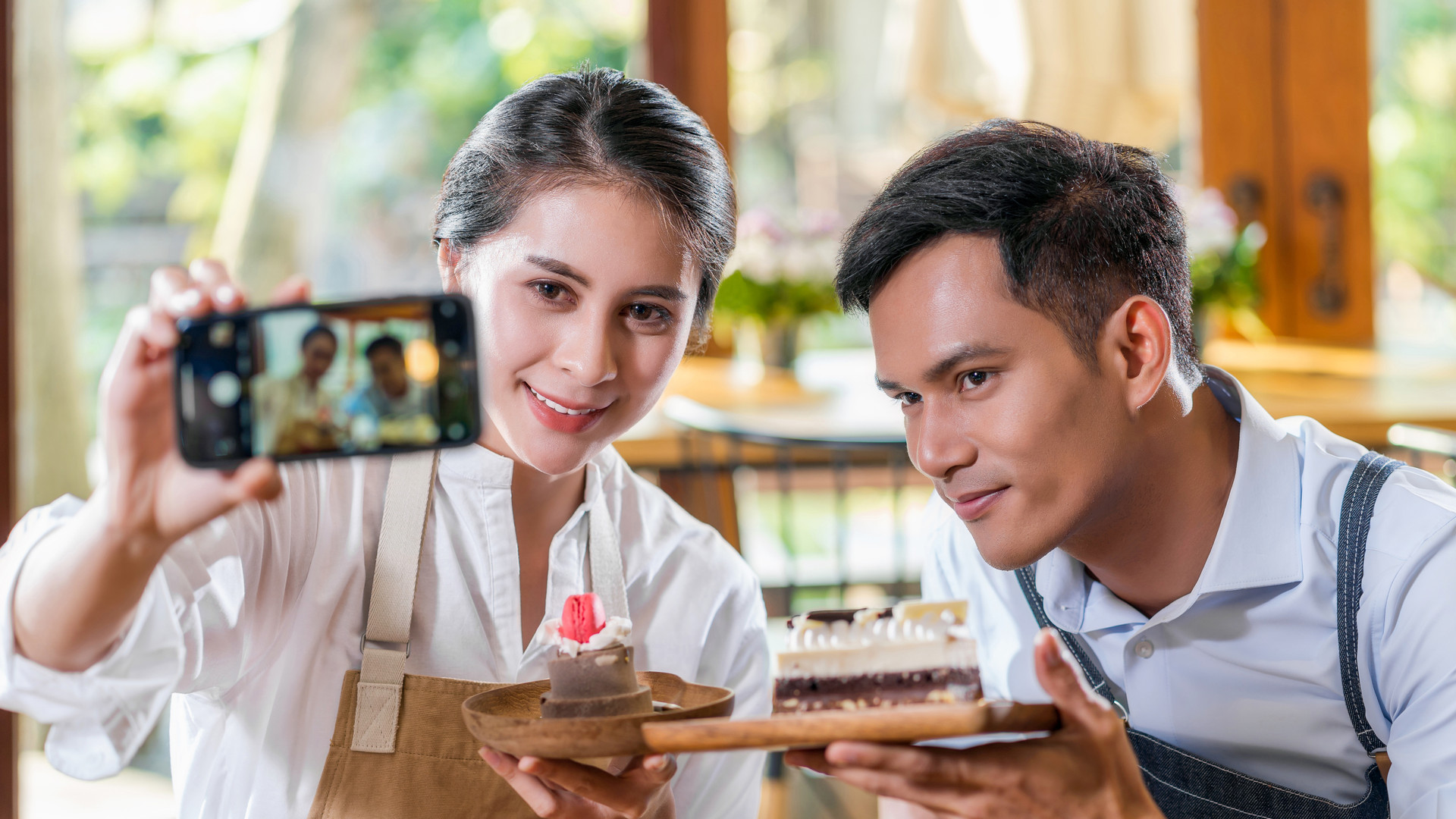 Couple Asian two partner of small business owner taking selfie and presenting the bakery in coffee shop when reccord vlog, Cake and dessert, entrepreneur blogger and startup business concept