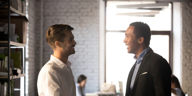 Friendly african and caucasian workers handshaking, welcoming new employee concept