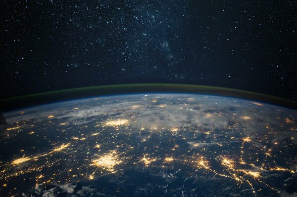 Digital illustration of Earth at night with glowing network connections spanning cities and regions across the globe, representing global telecommunications infrastructure.