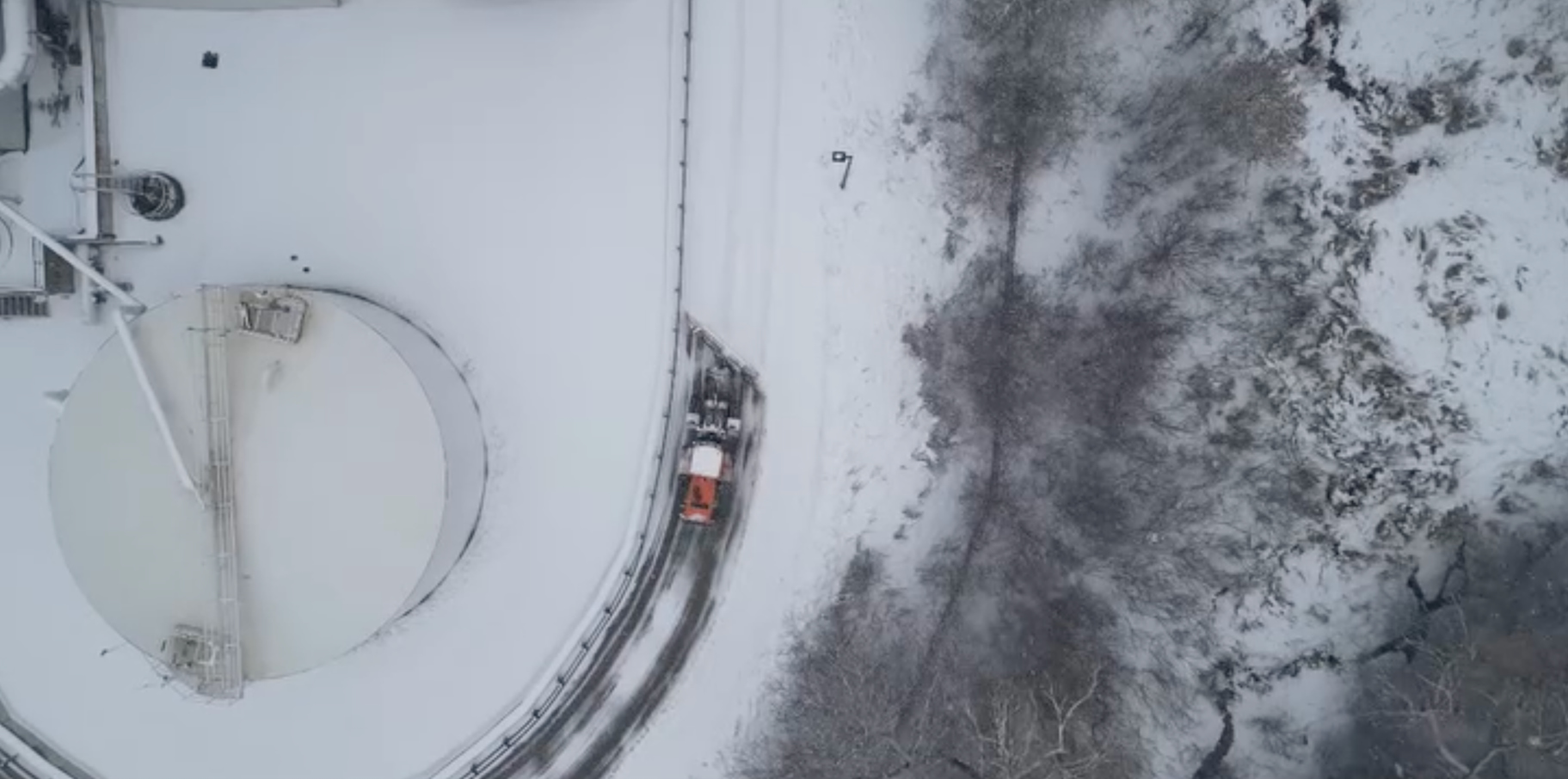 Overhead view of DEVELON machine clearing snow along a road.