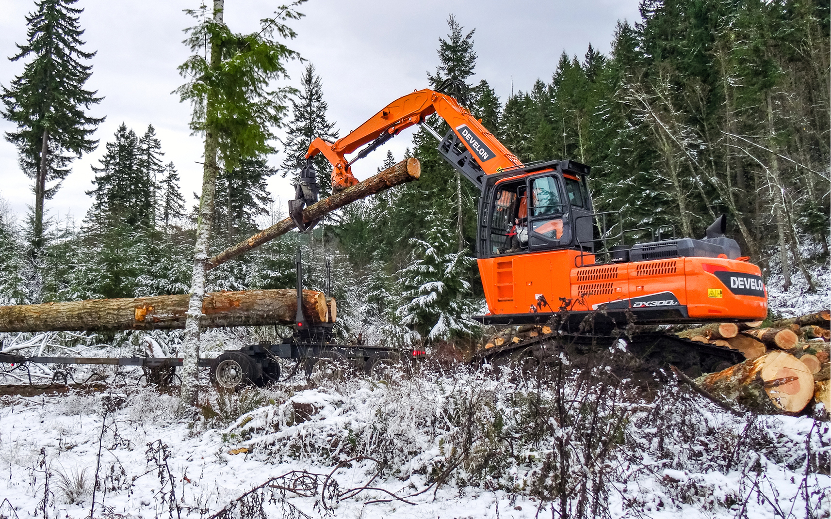 A DEVELON DX300LL-5 log loader moving logs.