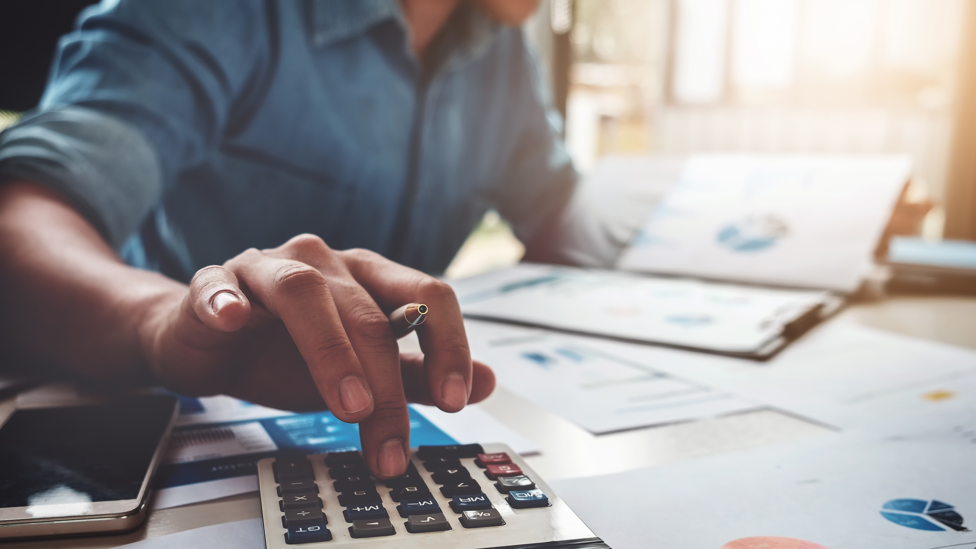 Business accounting concept, Business man using calculator with computer laptop, budget and loan paper in office.