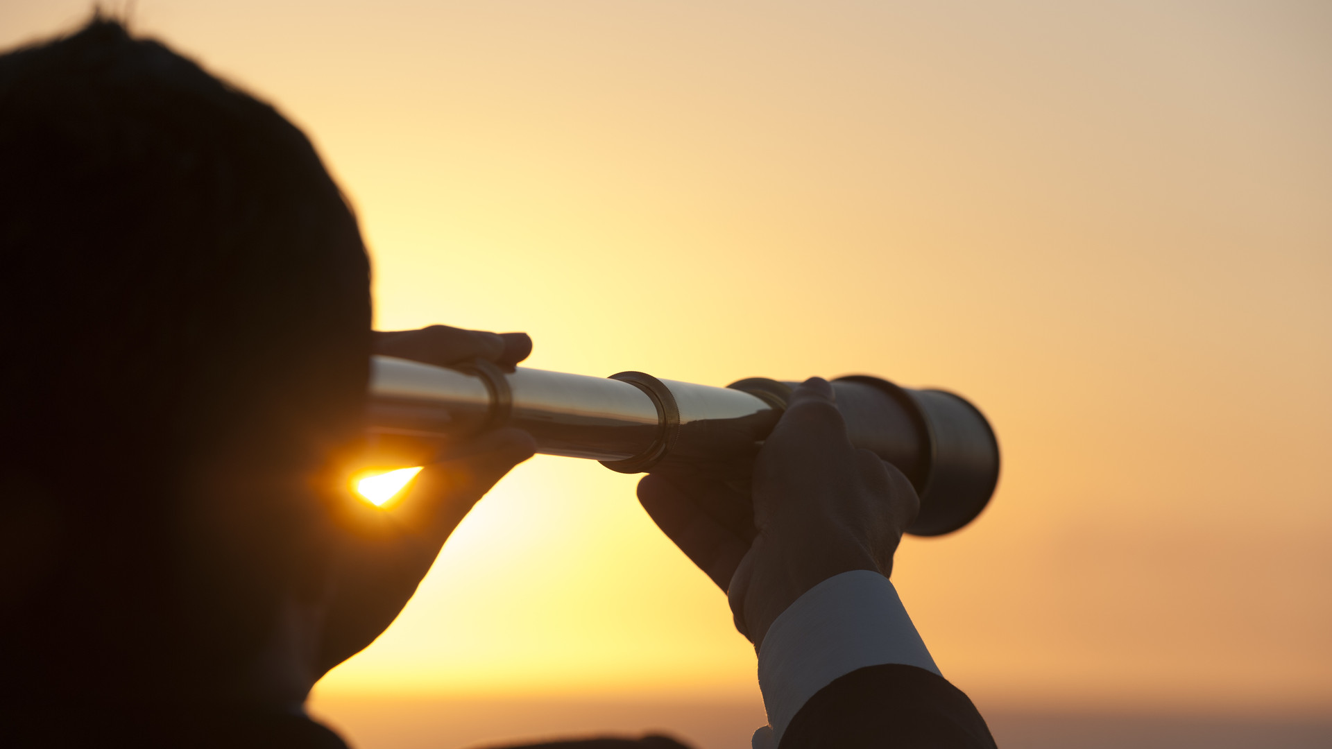 Businessman looking to the future with telescope