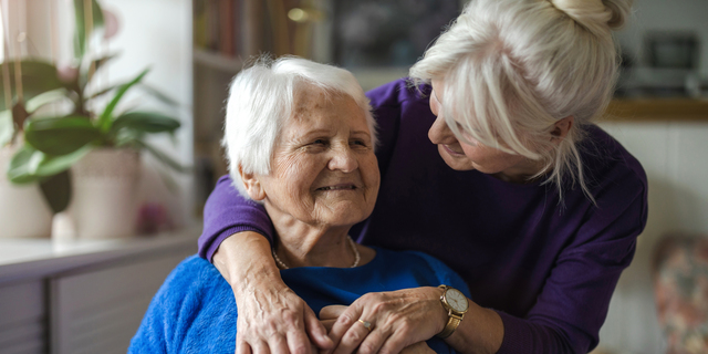 Woman hugging her elderly mother