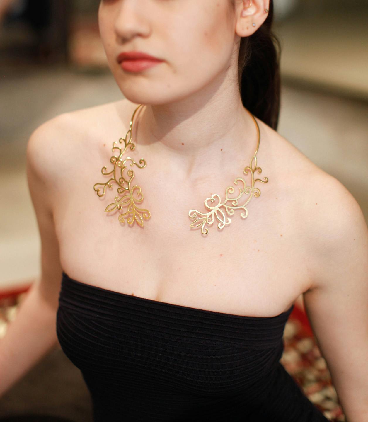 Woman wearing elegant gold filigree necklace in close-up portrait