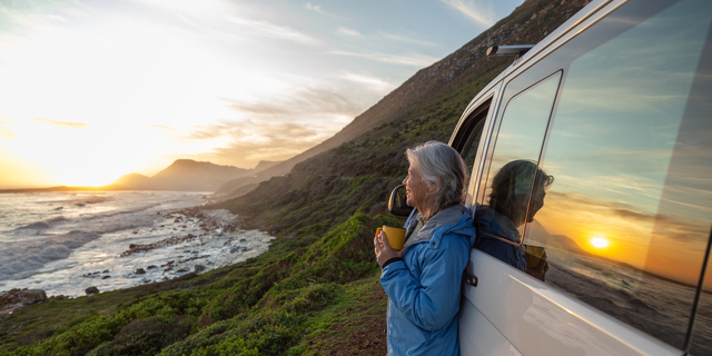 Senior woman enjoying sunset by the sea