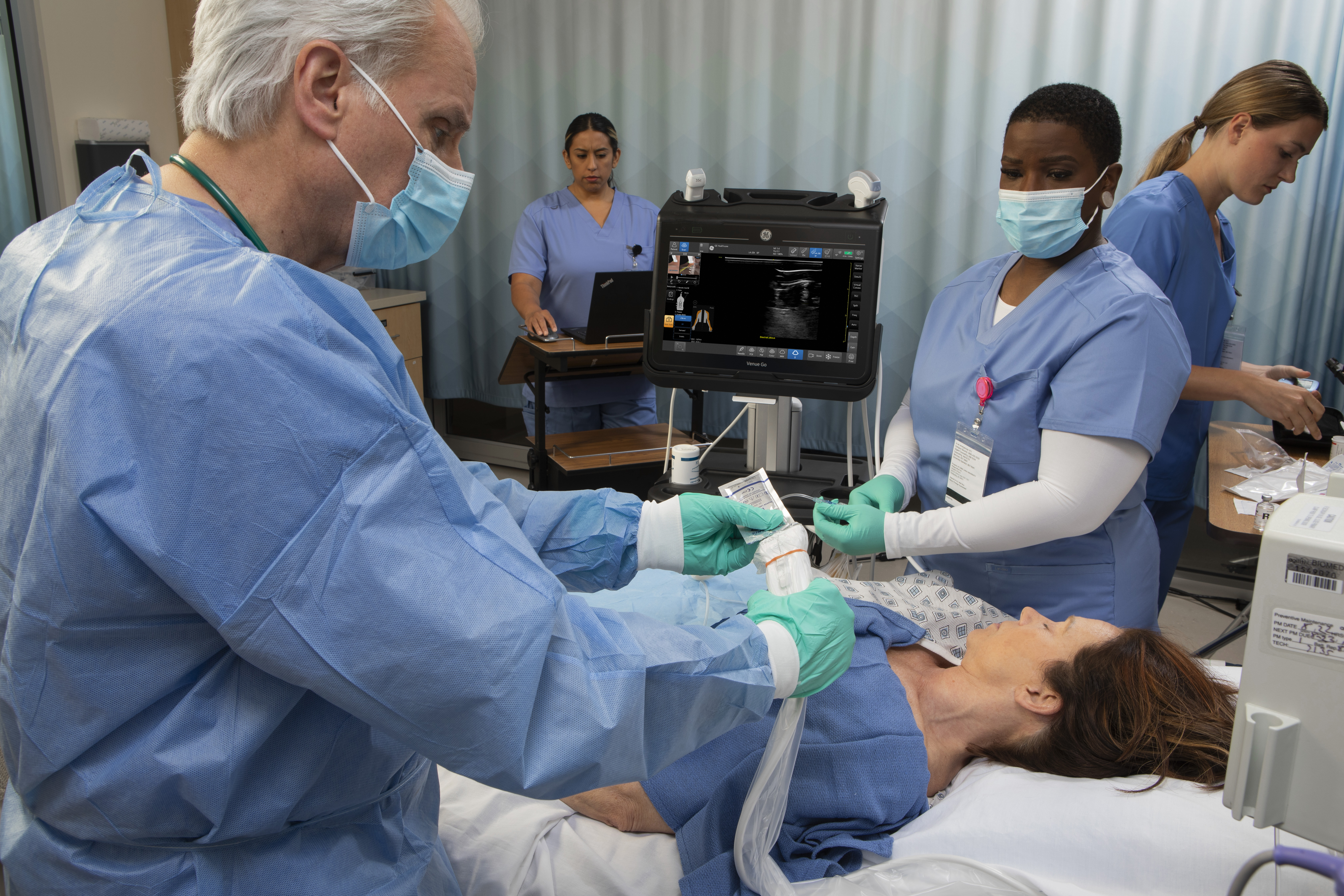 Clinicians in the Emergency Department utilize point of care ultrasound on a female patient.