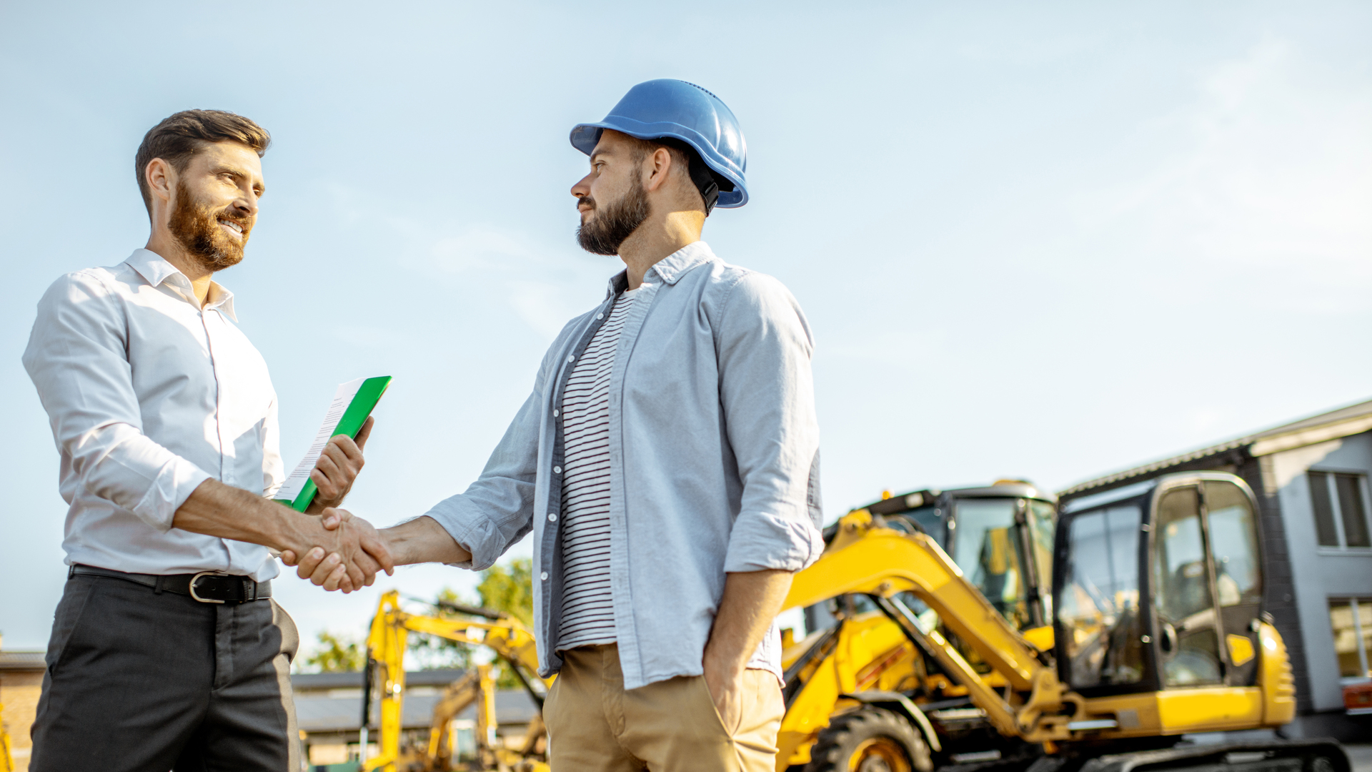 Builder with a sales consultant at the shop with heavy machinery