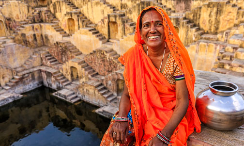 Indian woman resting inside stepwell in village near Jaipur, Rajasthan, India.