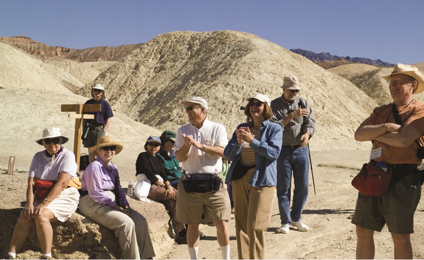 A group of Road Scholars laughing together in the desert outside of Death Valley National Park