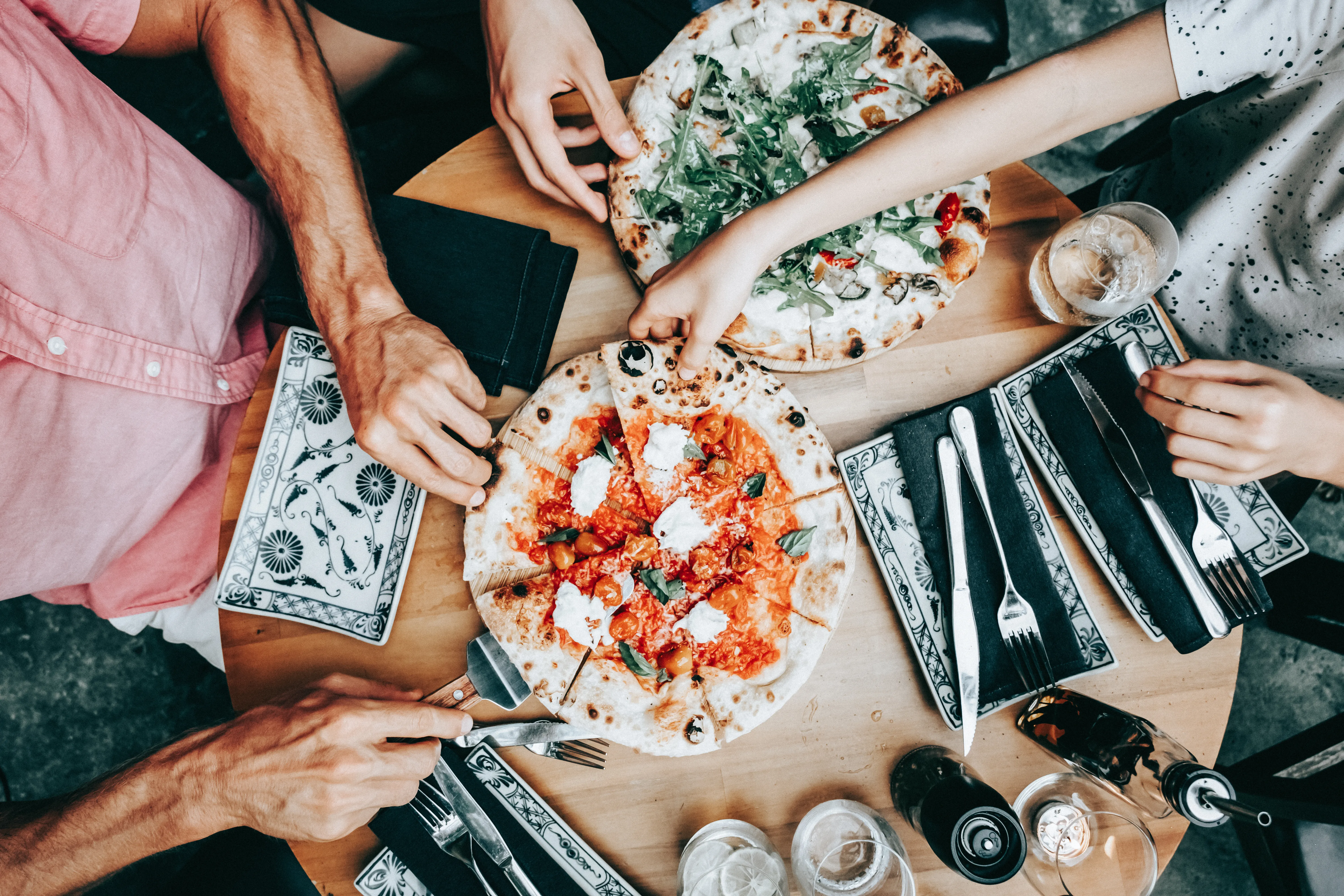 Family sharing pizza at a casual dining table. 