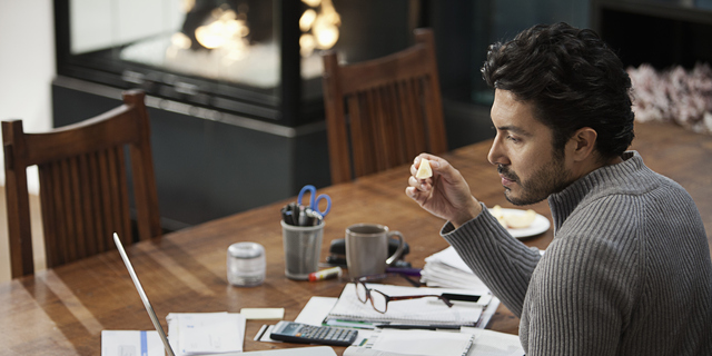 Hispanic man paying bills on computer