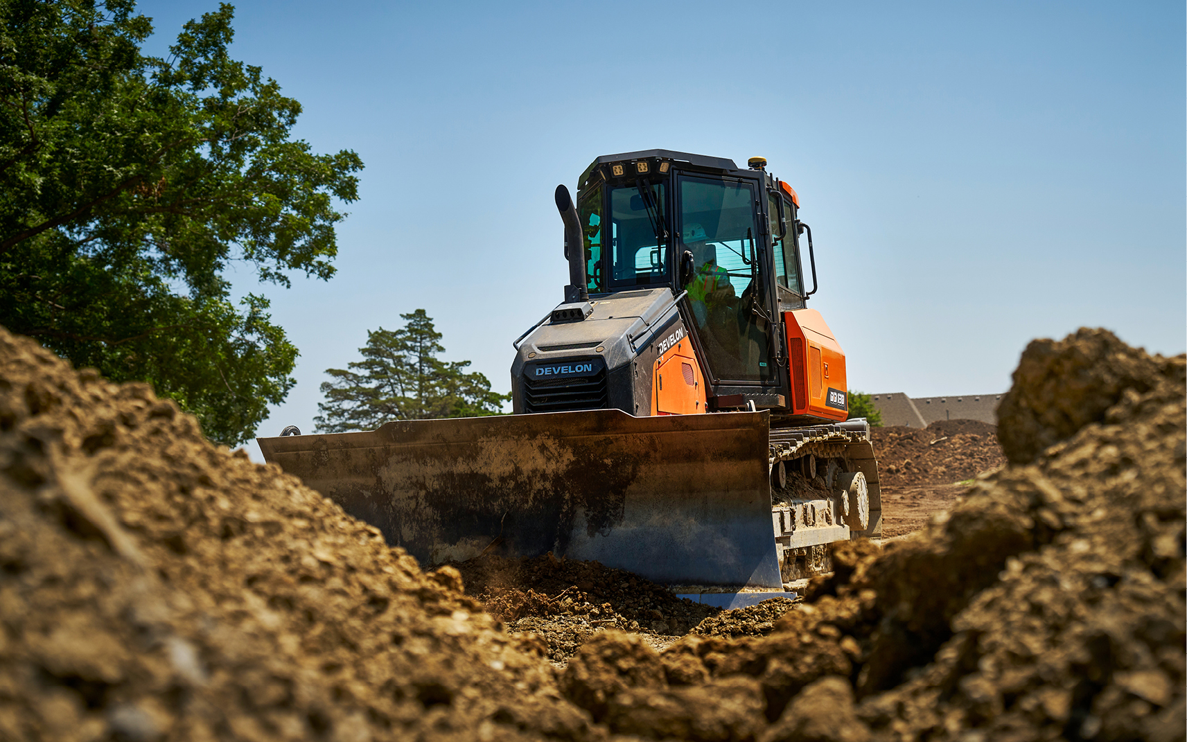 A DEVELON DD130 dozer pushing dirt with a dozer blade.