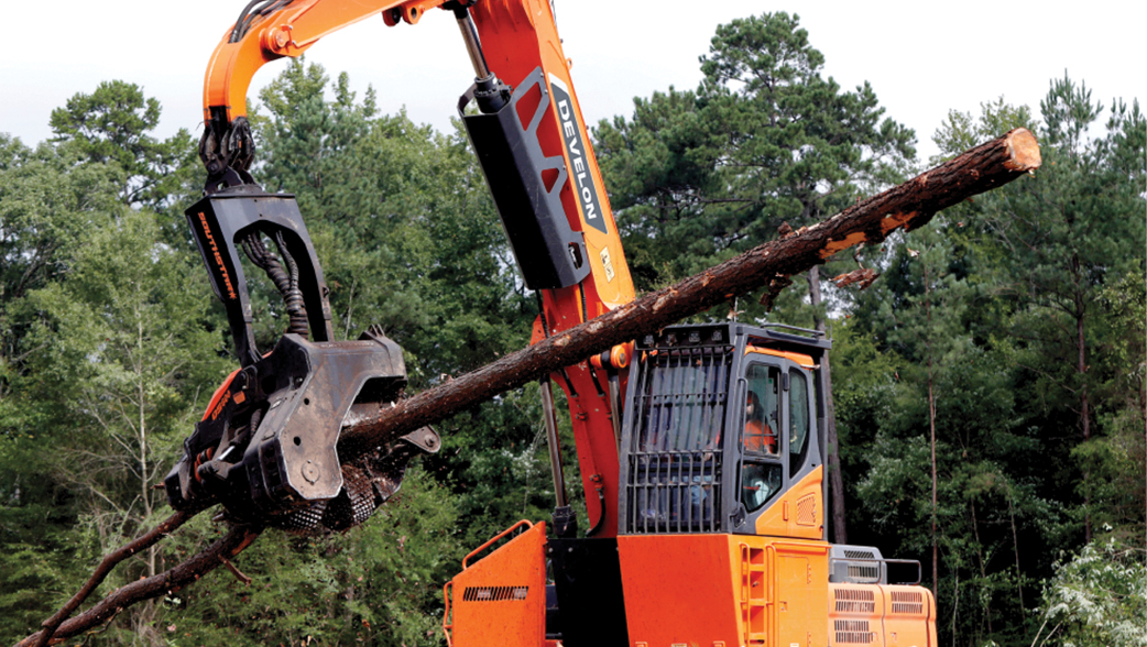 A DEVELON log loader moving a tree on a job site.