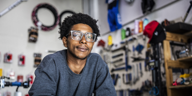 Portrait of bike shop owner leaning on counter