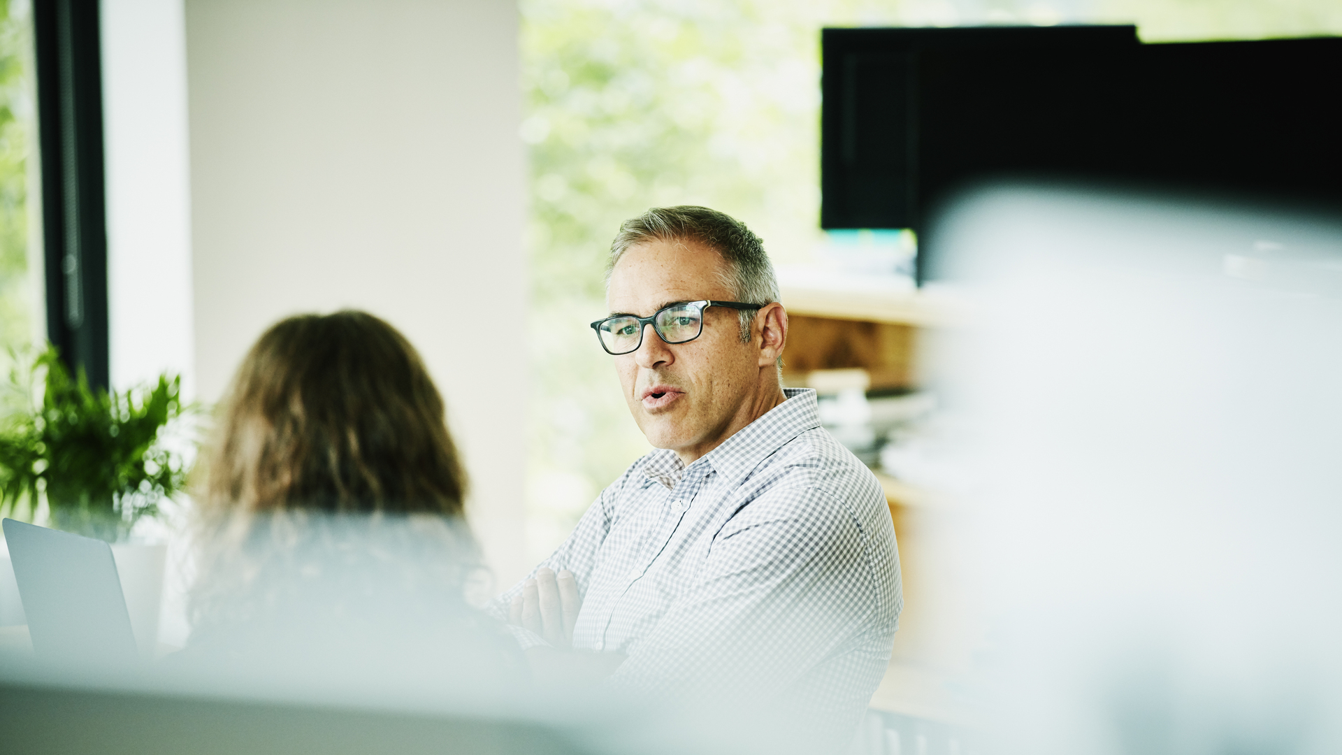 Businessman discussing project with client at office conference table