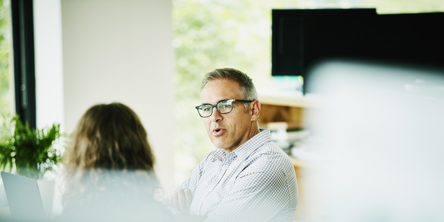 Businessman discussing project with client at office conference table